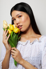 Charming young Asian woman romance bouquet of flowers near the face studio model unaltered