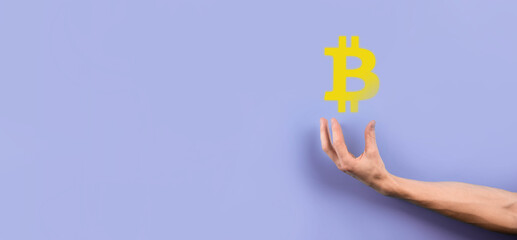 Male hand holding a bitcoin icon on blue background. Bitcoin Cryptocurrency Digital Bit Coin BTC Currency Technology Business Internet Concept.