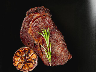 Top view beef steak grill with herbs rosemary, garlic and sauce on black background, overlay, flat lay, close up - 481114708