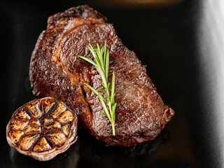 Top view beef steak grill with herbs rosemary, garlic and sauce on black background, overlay, flat lay, close up - 481114710