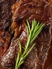 Beef steak grill with herbs rosemary, garlic and sauce on black background. Top view overlay, close up - 481114723