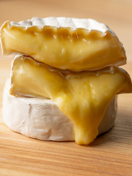 Tasty melted cheese camembert on wooden table close up, selective focus