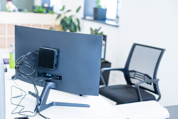 Cropped shot of portable office desk with computer devices, supplies and decorations on white table.