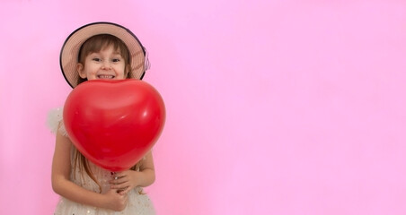 little girl in a smart dress and with a hat on her head. holds a large heart-shaped ball. joyful girl with red heart-shaped balloons on a colored background, valentine's day, copy space