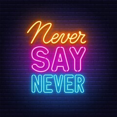 Never Say Never neon quote on a brick wall.