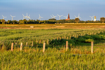 Die Landschaft der Ostseeinsel Fehmarns mit Blick auf Petersdorf mit Windrädern und Weiden