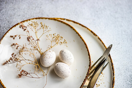 Overhead view of an Easter place setting with eggs and dried flowers on a table