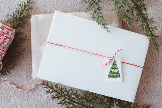 Overhead view of a wrapped Christmas gift and blank envelope
