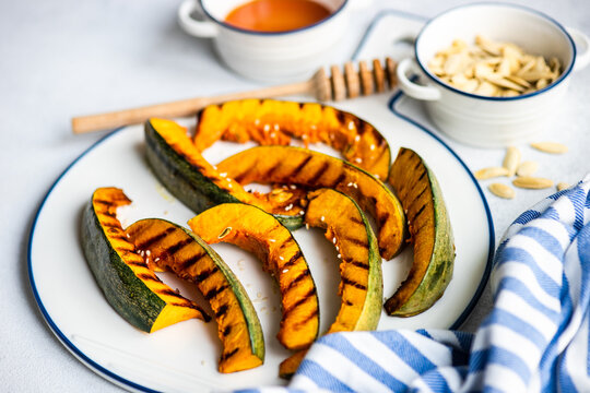Overhead view of Slices of honey roasted pumpkin with pumpkin seeds and pumpkin soup