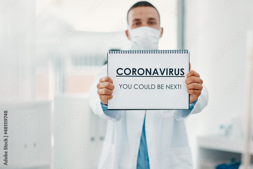 Poster it can strike anyone at anytime. shot of a scientist holding a sign with coronavirus-you could be ne