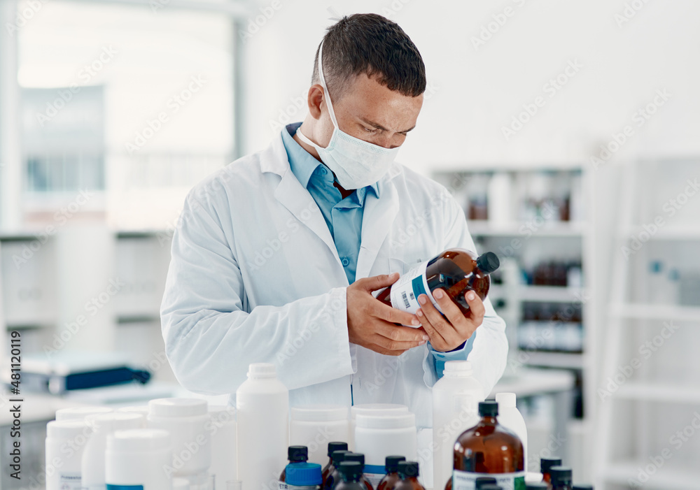 Poster unmasking the virus. shot of a young scientist analysing medication in a laboratory.