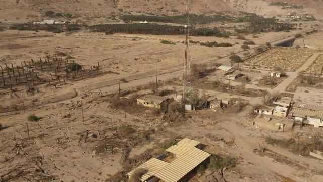 Tilting aerial footage of abandoned ghost town of Ein Gedi, where receding water levels of the Dead Sea lead to sinkholes and craters.