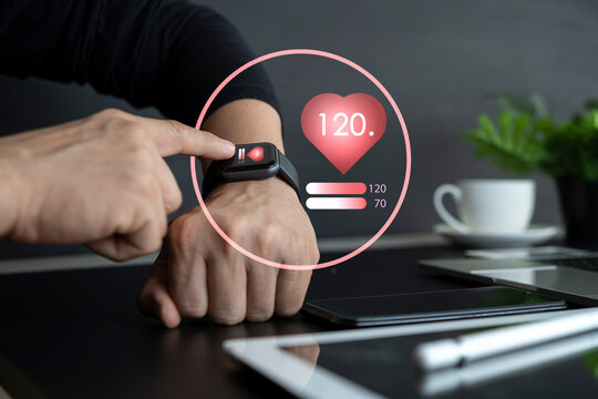 close up of hands with heart icon on smart watch