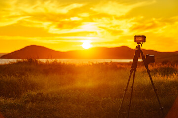 Naklejka premium Camera taking picture of sunset over sea