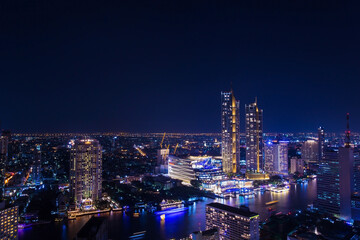 Naklejka premium City center buildings along the Chao Phraya River, Bangkok at night, Along the river have many hotel and hight building for business. Bangkok is centre for investment. one of colourful cities in Asia.