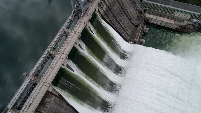 Aerial tilt side view of water discharge at hydroelectric power plant