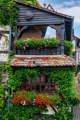 Fototapeta na wymiar Traditional Alsatian half-timbered houses with tiled roofs and street flowers in Strasbourg