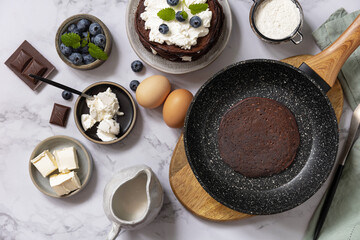Healthy breakfast. Ingredients for cooking and delicious crepes with blueberries and ricotta on a marble tabletop. Top view flat lay.