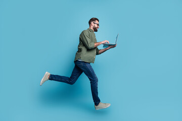 Profile photo of nice freelancer guy jump hold netbook typing email wear specs green shirt isolated...