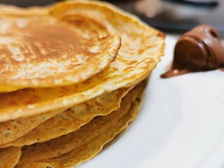 Detail of a plate of pancakes with chocolate for breakfast or as a sweet or savoury snack.