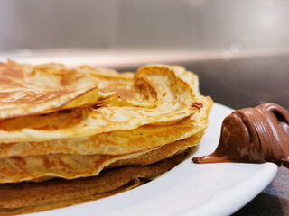 Detail of a plate of pancakes with chocolate for breakfast or as a sweet or savoury snack.