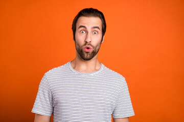 Photo of young man astonished bad fake information pouted lips isolated over orange color background