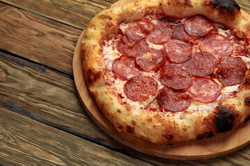 Pepperoni pizza on rustic, vintage style wood background. Top view