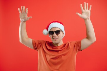Naklejka premium concept people, body language, approval, recommendationan excited man Santa Claus hat isolated on red studio background with space for text