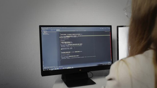 Programmer girl scrolling HTML web page code. Programming