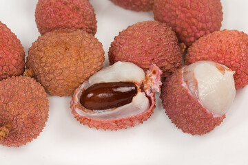 Partly opened ripe lychee fruits against the whole fruits