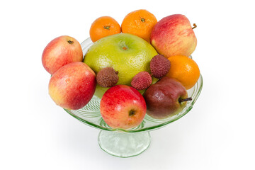 Different fruits in vintage glass bowl on a white background