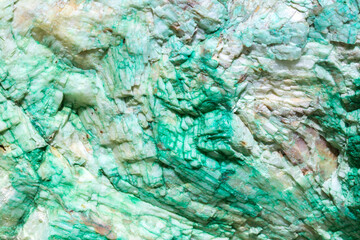 Background from dracocene crystals of stones. Fluorite stone in the rocks of the adit. Mineral stones in their natural environment. Semiprecious stones texture.