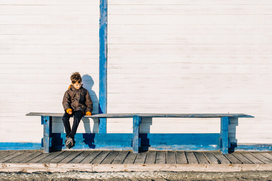 Autism awareness concept. Autism boy sits alone on a blue bench