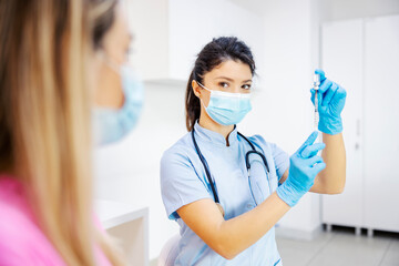 A nurse preparing vaccine for her patient at hospital. Pharmaceutical, medicine, vaccination and...