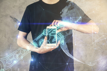 Double exposure of man's hands holding and using a digital device and tech theme hologram drawing....