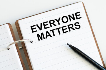 everyone matters on a notepad on a table next to a black marker, a business concept