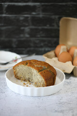 Banana cake cut in piece on white plate in rustic mood.