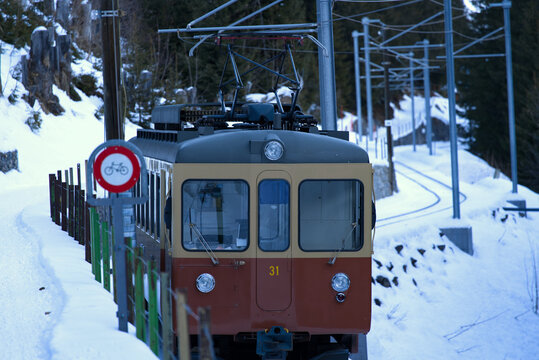 Train of Lauterbrunnen M&uuml;rren Mountain Railway LMB between station Gr&uuml;tschalp and M&uuml;rren on a sunny winter day. Photo taken January 15th, 2022, Lauterbrunnen, Switzerland.