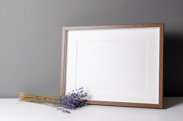 Horizontal wooden frame mockup for artwork, photo and print presentation with dry lavender flowers. Modern minimalist interior design.