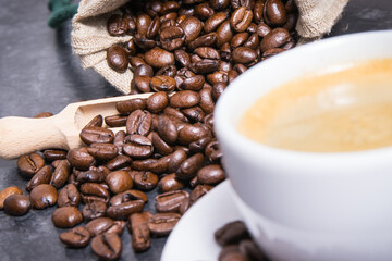 White cup of coffee and roasted fragrant dark coffee grains