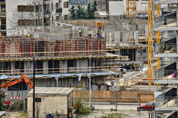 Construction workers install formwork and iron rebars or reinforcing bars for reinforced concrete...