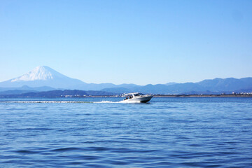 江ノ島の海を走るボートと冬の富士山