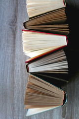 Bunch of vintage hardcover books on wooden background. Top view.