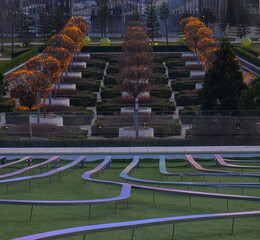 Krasnodar. Russia.01.01.2022 Galitsky Park at sunset. Luminous paths run down the group to the trees. The trees are lit with lights. Dust.