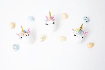 Easter eggs decorated with unicorn stickers on a white background. Copy space. Happy holiday. Top view. Background for Easter.