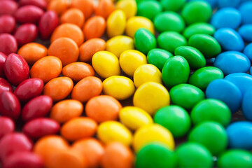 Fototapeta na wymiar Close up of rainbow colored candy, sugar coated candies. Candy delicious sweets background. Colorfull candies.
