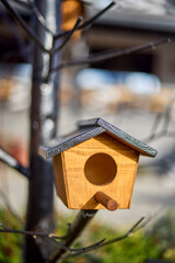 a wooden birdhouse placed on a tree to attract birds