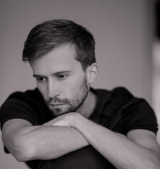 Fototapeta premium Black and white portrait of young pensive man.