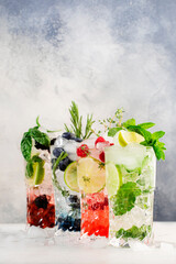 Cocktails or mocktails cold drinks. Classic summer refreshing long drink in highballs with berries,...