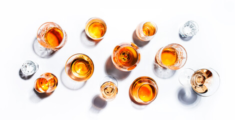 Strong alcoholic drinks, hard liquors, spirits and distillates in glasses: vodka, cognac, whiskey and other. White background. Hard light, copy space - obrazy, fototapety, plakaty